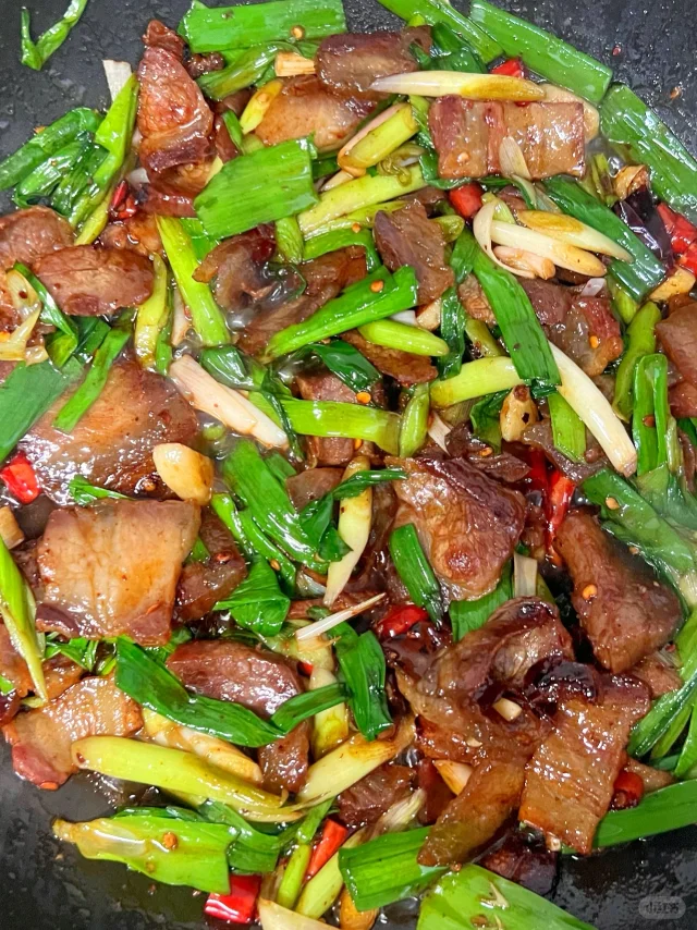 一盘刚出锅的金黄色锅贴整齐排列在白色瓷盘中