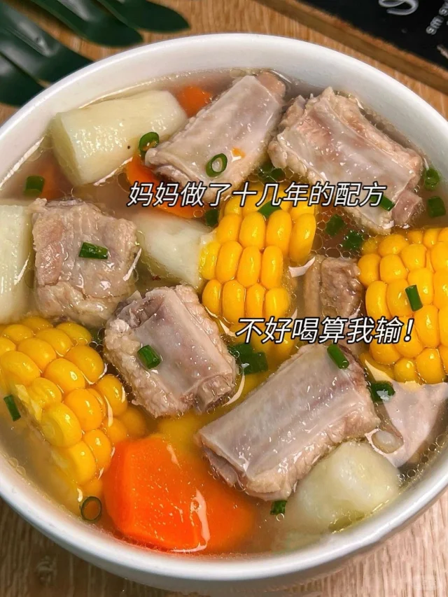 中式砂锅中慢炖胡萝卜山药排骨汤，汤色清亮微黄，可见橙红胡萝卜块、灰白山药段及淡粉色排骨，表面浮少量金黄色油星，撒有葱花