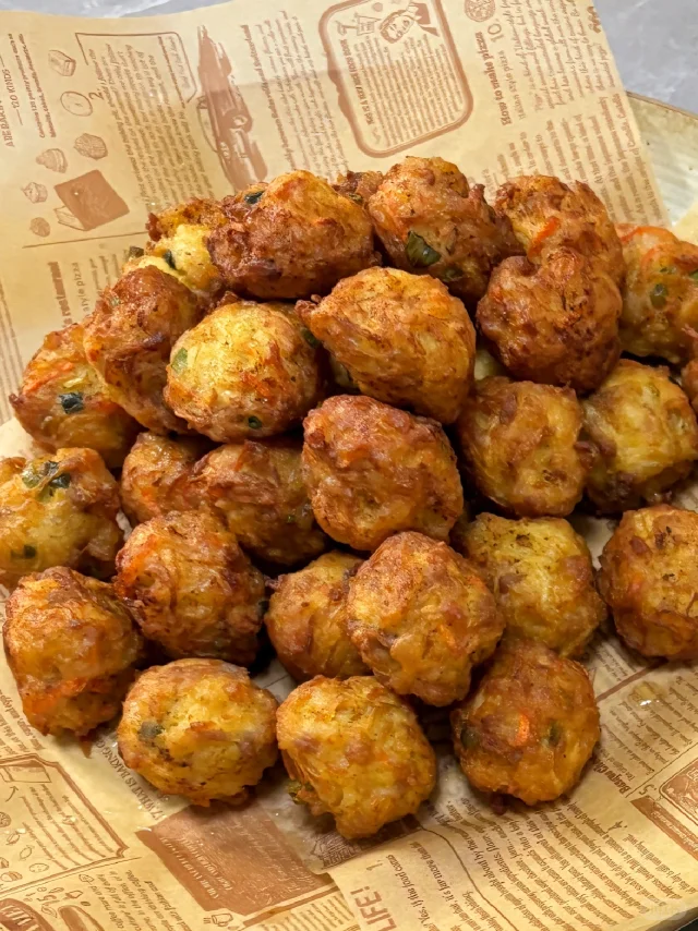 厨房操作台上的大碗中混合着白色萝卜丝、粉色肉末、葱姜碎及调味料，一只手正用筷子沿顺时针方向搅拌馅料