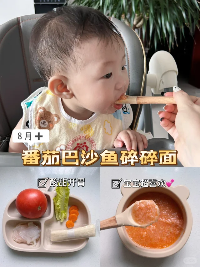 真实婴幼儿进食红肉番木瓜泥生活场景,强调安全餐具、适宜质地(无颗粒)、合理份量(约30–40g/餐),体现家庭化、可操作性辅食添加方式 婴幼儿手捧小碗食用木瓜泥场景:18个月左右亚洲幼儿坐餐椅中,双手扶碗,碗内为细腻橙红色木瓜泥,表面点缀少量黑芝麻(提供维生素E协同抗氧化),背景为家庭厨房木质台面