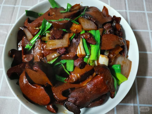 中式家常菜场景：青瓷碗中盛放凉拌大葱丝，配芝麻油、陈醋、少许海盐，葱丝翠绿挺括，表面可见晶莹醋珠，背景虚化呈现厨房窗台上的新鲜大葱植株