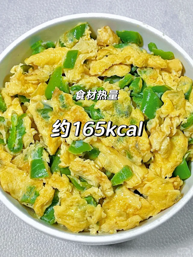 厨房操作实拍：厨师左手持线椒段（去蒂留籽），右手将搅匀蛋液沿锅边缓缓淋入热油中，锅内火焰呈集中蓝色，油面平静无剧烈翻滚