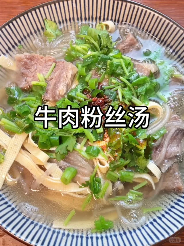 高清场景图:西湖牛肉羹出锅瞬间,展示‘关火撒粉’关键动作;汤体澄澈无浮油,牛肉丝纤细均匀,胡椒粉呈自然飘散状态,体现温度与时机精准把控 家庭厨房实拍:不锈钢锅中盛着清澈见底的西湖牛肉羹,表面浮着细嫩牛肉丝与嫩豆腐丁,一撮灰白胡椒粉正被竹勺轻扬撒入,热气氤氲,光影柔和