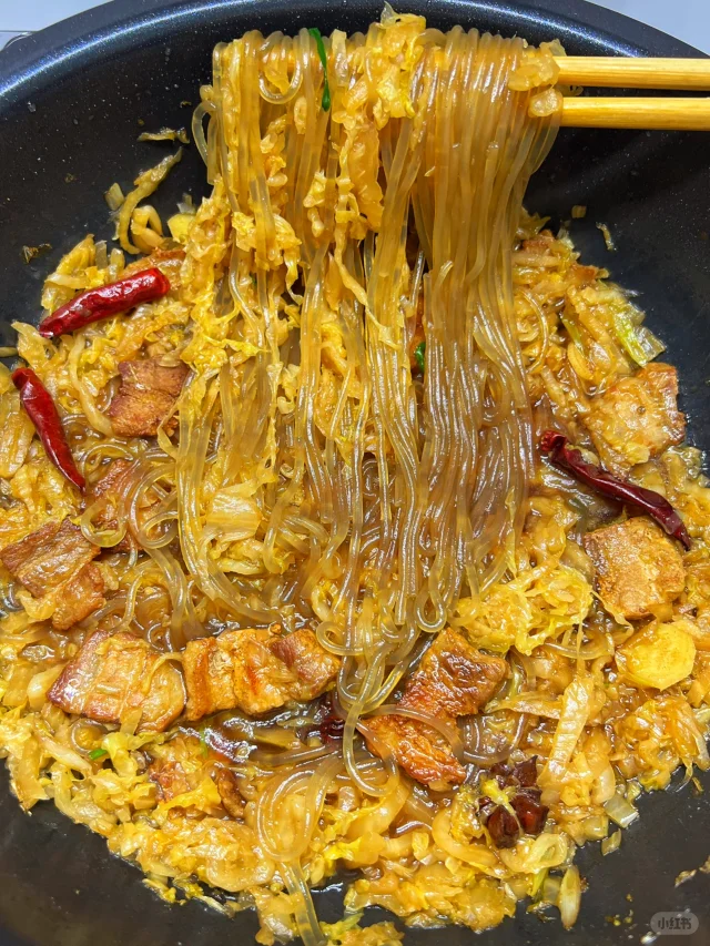 一锅热气腾腾的白菜豆腐五花肉炖粉条盛放在白色瓷深盘中,五花肉油亮诱人,豆腐完整不碎,粉条晶莹剔透缠绕其间,白菜呈半透明状,汤汁浓稠适中,表面点缀翠绿葱花,旁边配有一碗白米饭,整体画面温暖诱人,体现家常美食的幸福感 成品装盘图