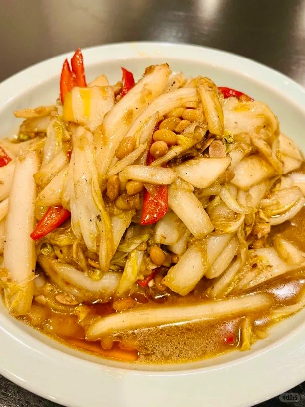 青白相间的炒豆角包菜盛于白色圆盘中,豆角段油亮微焦,包菜片舒展半透明,表面散落几粒金黄蒜末与红椒丝,无汁水渗出,呈现干香油润质感 成品装盘特写:翠绿豆角与嫩白包菜交织