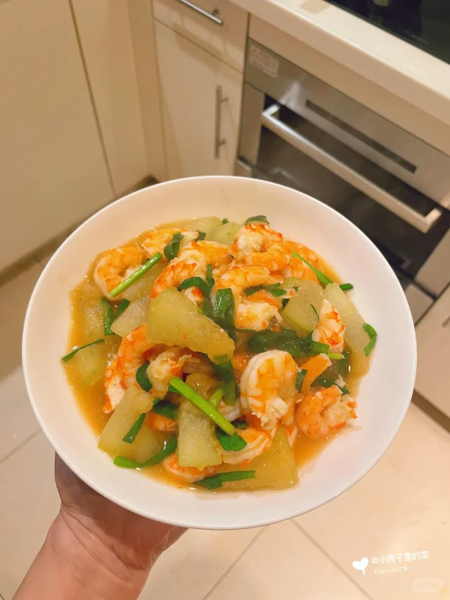 冬瓜片与虾仁在锅中翻炒的特写图