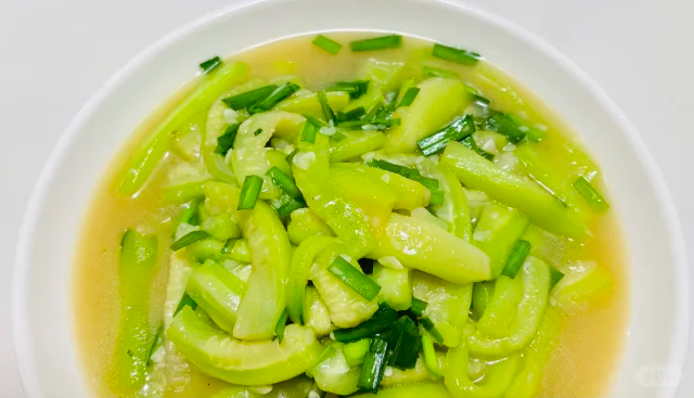 一盘清炒丝瓜花成品,搭配米饭摆放在餐桌上,色彩清新,香气扑鼻 丝瓜花成品图