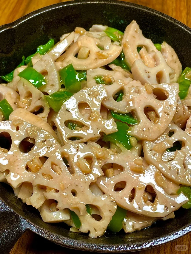 清炒莲藕配青椒成品特写，藕片呈半透明玉白色，边缘微焦，青椒翠绿鲜亮，锅气十足，盛于青花瓷盘中