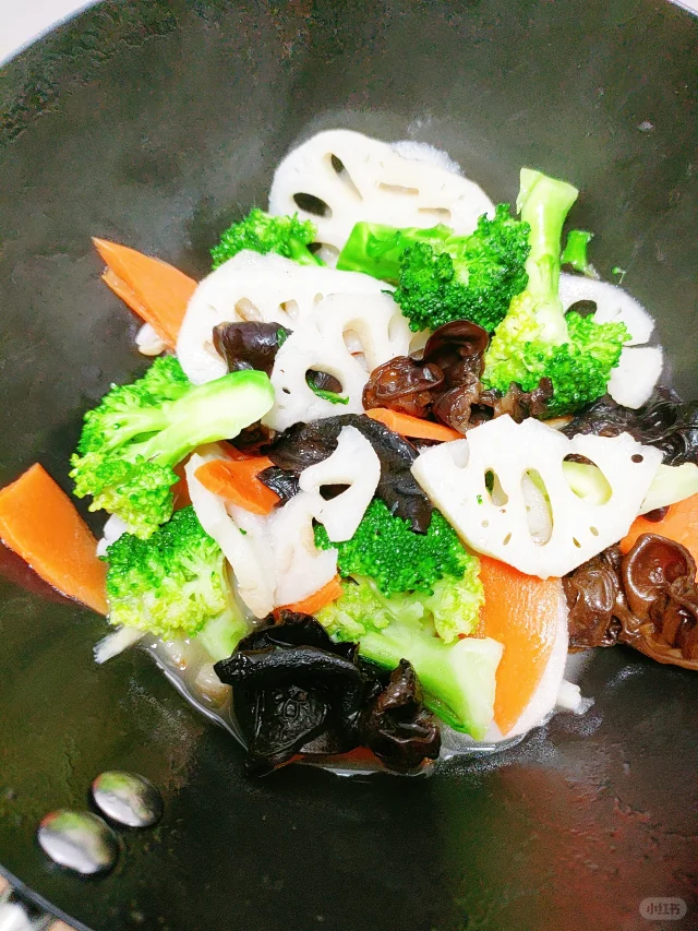 一道刚出锅的藕片炒荷兰豆炒木耳特写照片,菜肴盛放在白色圆盘中央,色泽分明,藕片晶莹、荷兰豆碧绿、木耳油亮,表面微微泛光,旁边点缀几片香菜叶,整体呈现高级家常菜质感 成品特写图