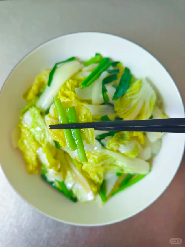 高清特写:清炒娃娃菜成品图,突出食材新鲜度、少油质感及天然色泽,展现‘清’字精髓——无浓酱、无勾芡、无过度软烂 清炒娃娃菜特写:一盘刚出锅的翠绿娃娃菜,叶片完整微卷,表面油润反光但无浮油,可见少量蒜末和红椒丝点缀,背景为青花瓷浅盘,体现家常健康烹饪